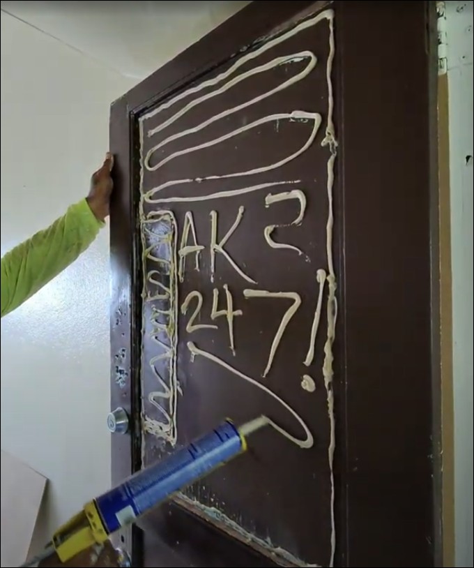 AK247 handyman performing door repair and sealing