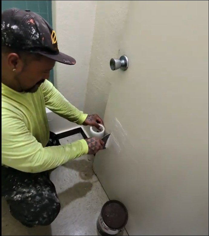 AK247 handyman patching a wall on a job site in Oahu
